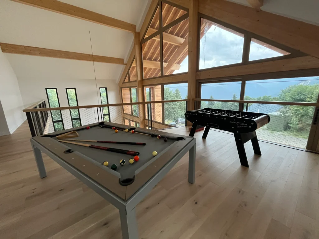 Salle de jeux avec billard et baby-foot au Black Arves Luxury Lodge
